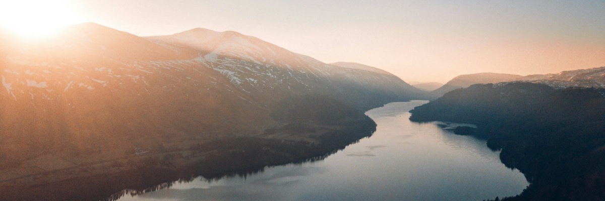 a river and narrow valley winding between small mountains, image by unsplash